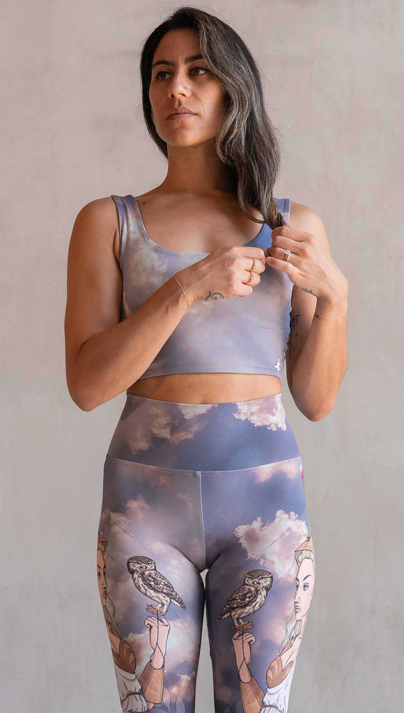 Side view of model wearing WERKSHOP Athena and Valkyrie reversible top. This top is two way reversible and each side matches either our Athena or Valkyrie leggings. The Athena side of the top features a cloudy blue sky with rays of sunlight. The Valkyrie side features an ominous taupe and warm gray stormy sky with lightening bolts