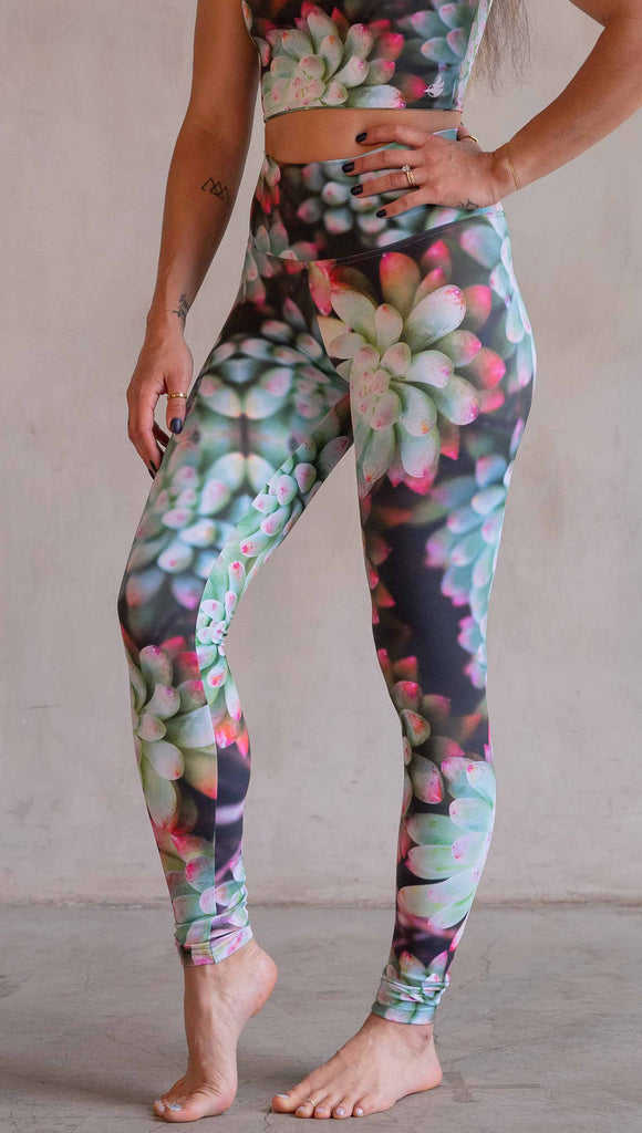Model wearing WERKSHOP Mojave Sunset Athleisure Leggings. The print on the leggings features photo-real succulents with bright pops of green and hot pink.