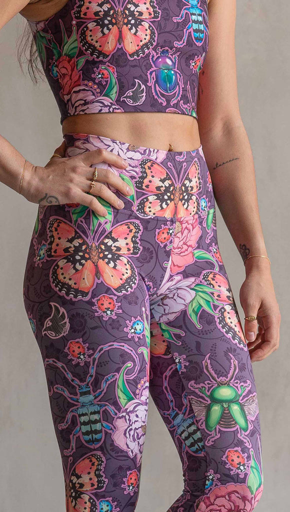 Zoomed in view of model wearing WERKSHOP Enchanted Garden Athleisure Leggings. The fabric is printed with original artwork by our Female Founder, Chriztina Marie. The artwork printed not the fabric features Butterflies, Beetles and Peonies over a warm fuchsia with bright bold pops of color on each beetle and Butterfly.