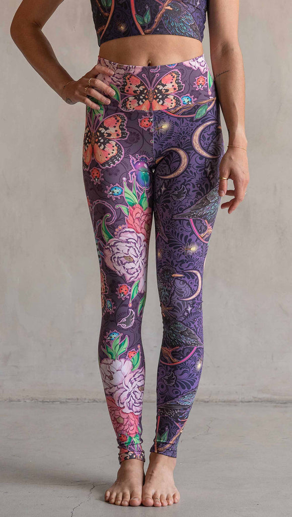 Front view of model wearing WERKSHOP Starlings and Enchanted Garden Mashup Leggings. The fabric is printed with original artwork by Chriztina Marie. Each leg features different artwork. The wearer’s left leg has European Starlings perched on a branch near a crescent moon and fireflies. The colors are warm purples with pops of pink, gold and green. The wearer’s right leg features Butterflies, Beetles and Peonies over a warm fuchsia with bright bold pops of color on each beetle and Butterly.