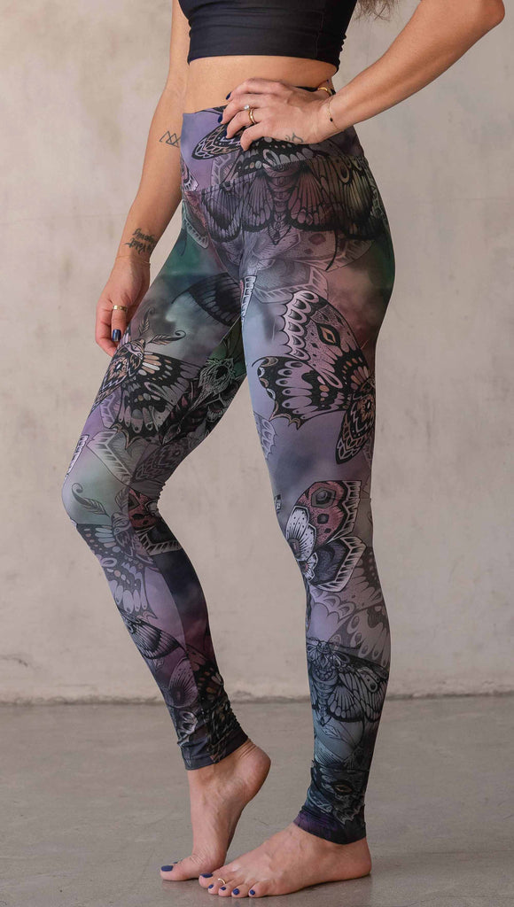 Side view of model wearing WERKSHOP Moths athlisure leggings. The artwork on the leggings is of hand drawn moths with muted pops of mauve and peach over an edgy "oil slick" inspired watercolor background.