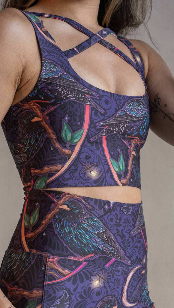 Zoomed in view of model wearing WERKSHOP Starlings and Enchanted Garden 4-Way reversible top. The fabric is printed with original artwork by Chriztina Marie. One side features European Starlings perched on a branch near a crescent moon and fireflies. The colors are warm purples with pops of pink, gold and green. The other side features Butterflies, Beetles and Peonies over a warm fuchsia with bright bold pops of color on each beetle and Butterly.