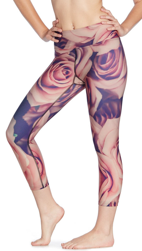 close up front view of model wearing printed capri leggings with all-over rose design motif