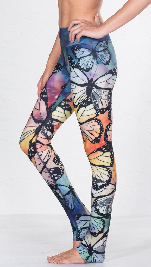 left side view of model wearing colorful butterfly themed printed full length triathlon leggings