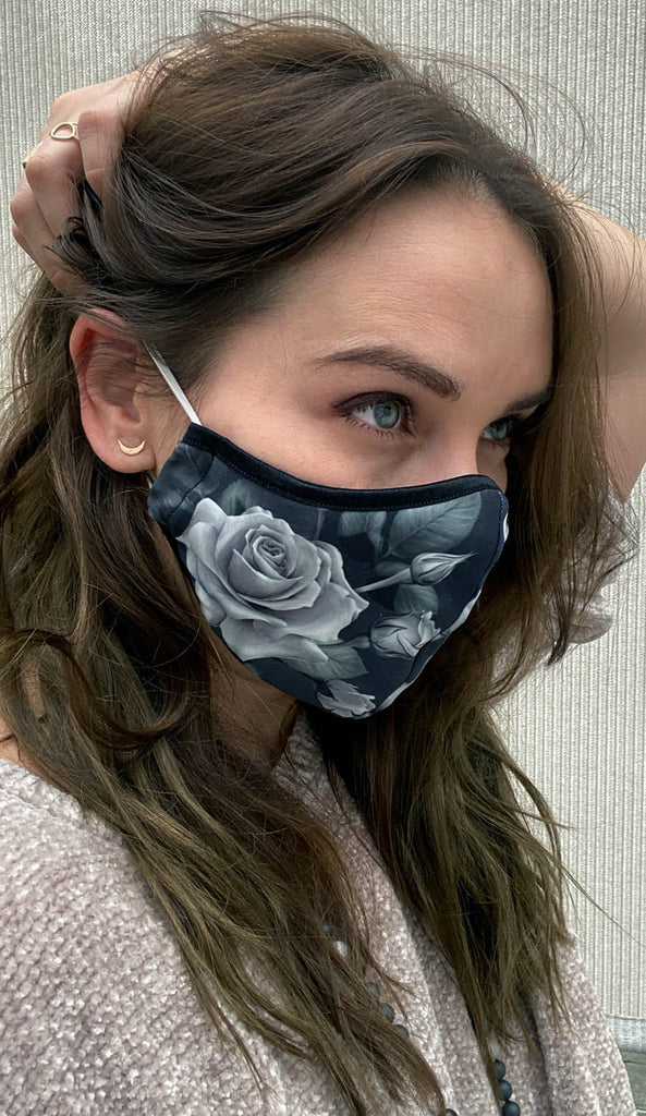 girl wearing face mask with black and white roses artwork 