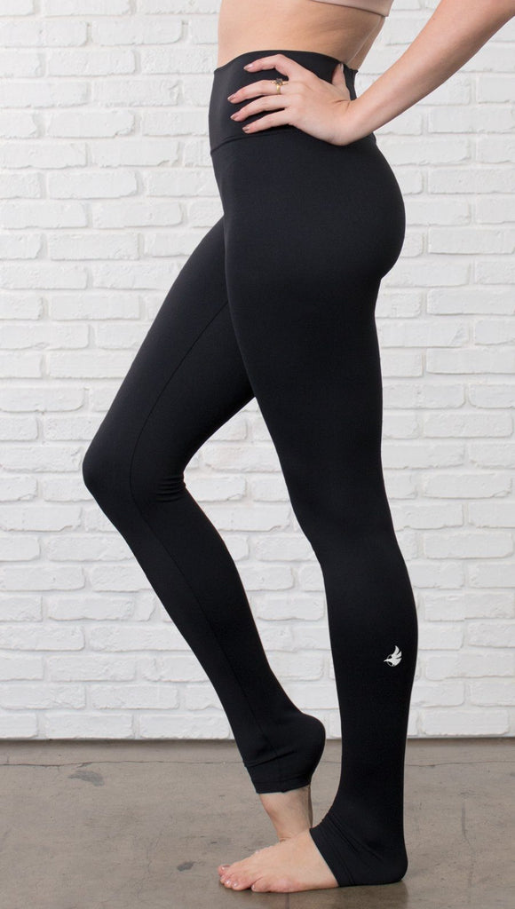 Closeup left view of model wearing black full-length leggings