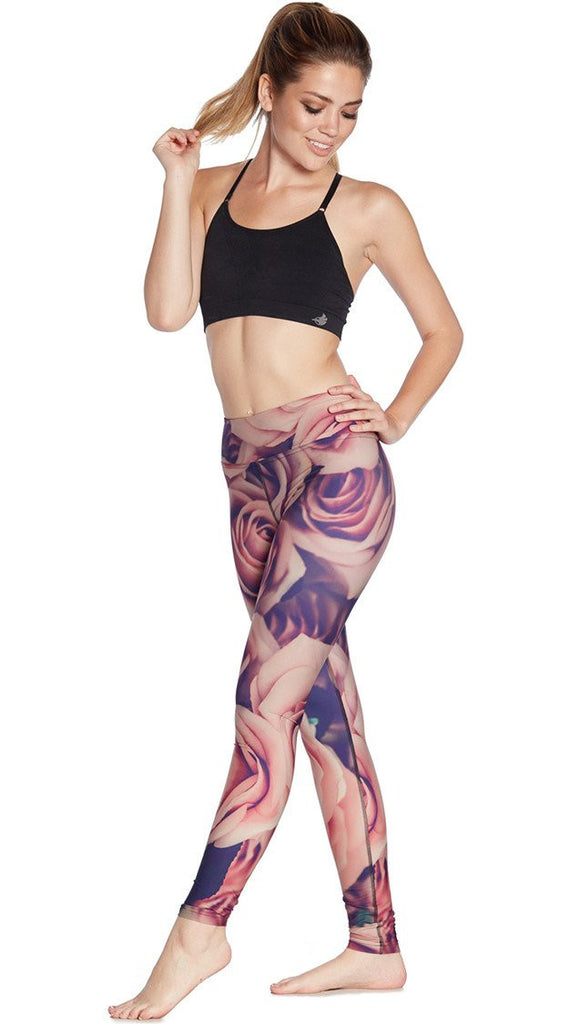 slightly turned front view of model wearing printed full length leggings with all-over rose design motif