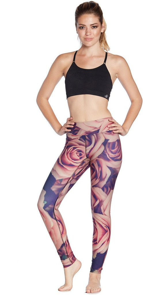 front view of model wearing printed full length leggings with all-over rose design motif and sports top
