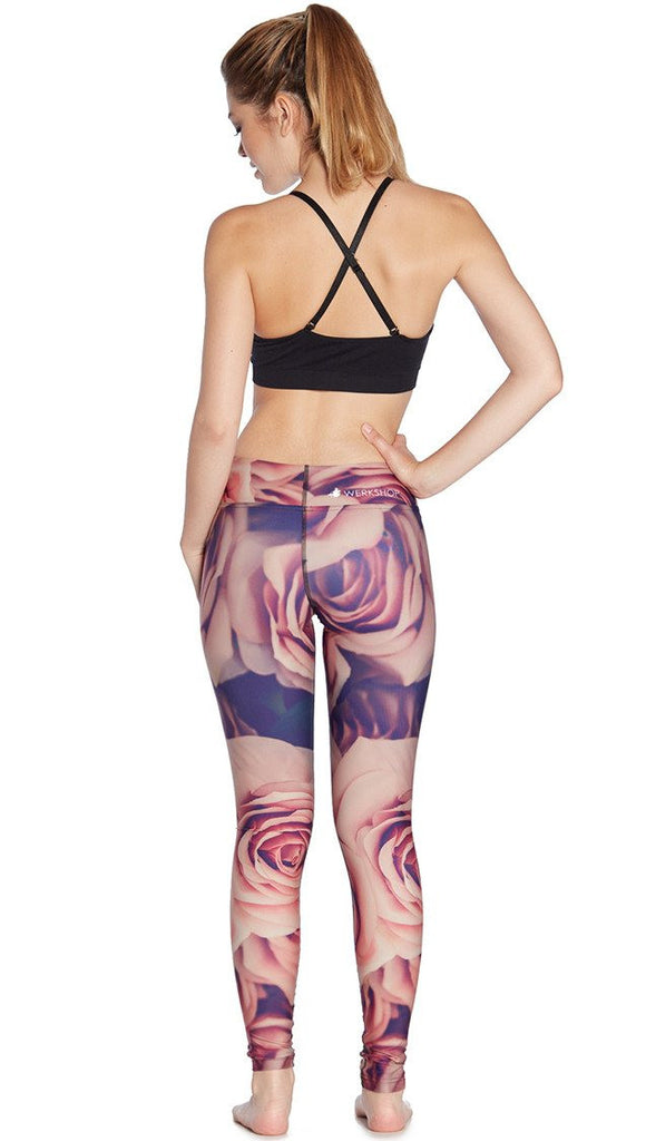 back view of model wearing printed full length leggings with all-over rose design motif and sports top