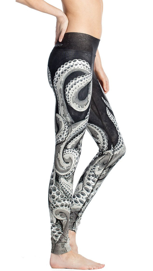 close up right side view of model wearing black and white tentacle themed printed full length leggings