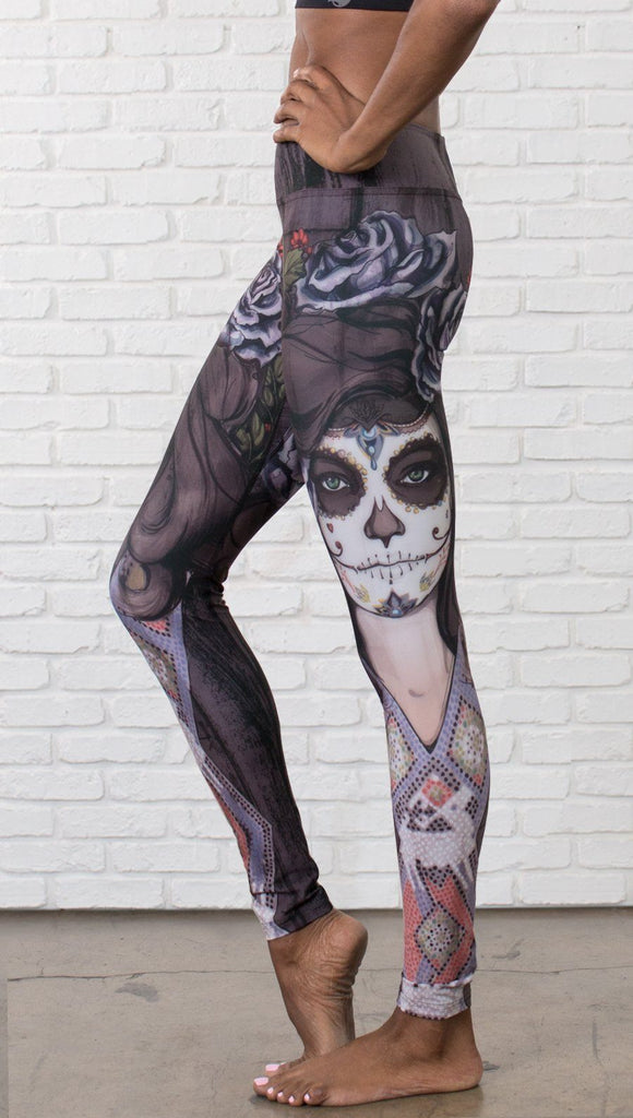 close up left side view of model wearing sugar skull themed printed full length leggings