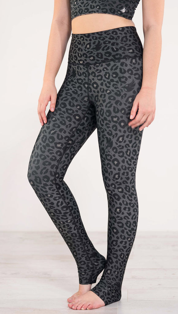 Enhanced view of model wearing reversible charcoal leopard print athleisure leggings in the colors gray and black