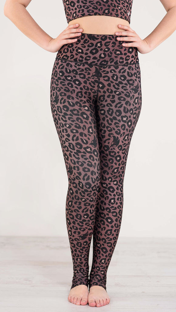 Front view of model wearing reversible red leopard print athleisure leggings in the colors dusty red and black
