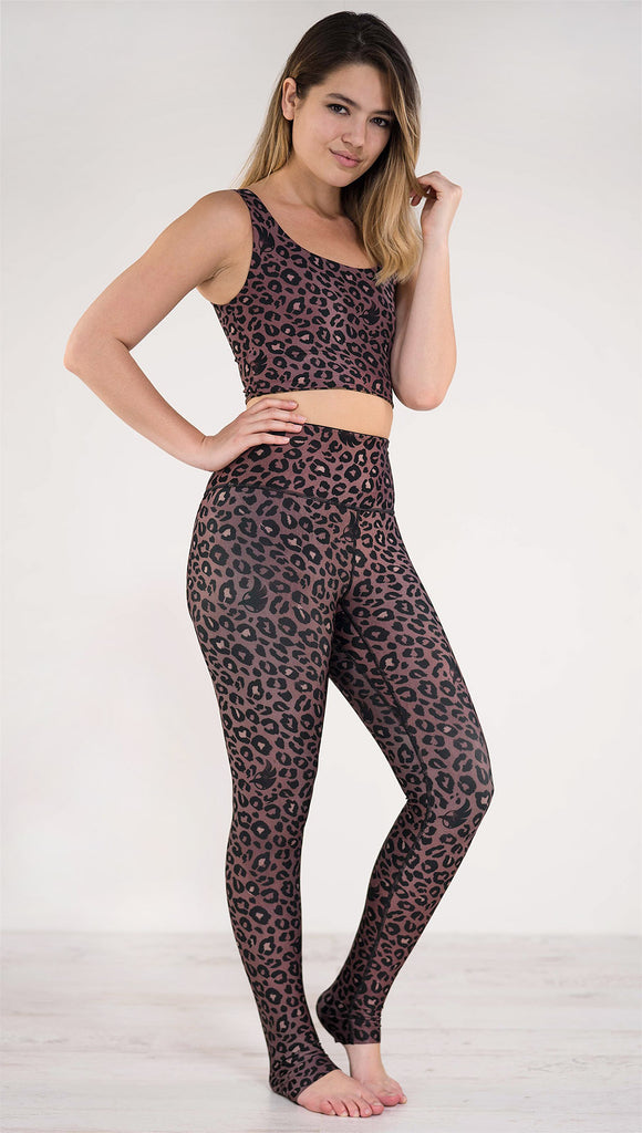 Right side view of model wearing the reversible red leopard print athleisure leggings in the colors dusty red and black