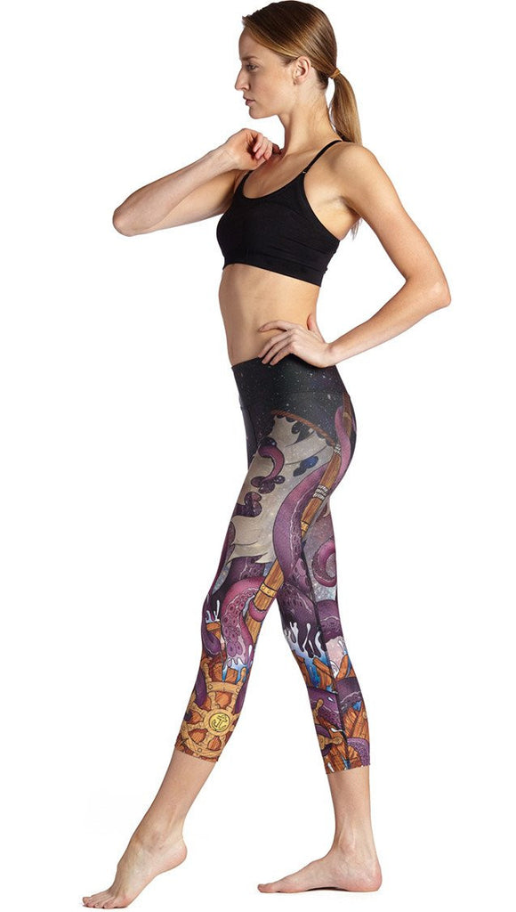 left side view of model wearing mythical octopus themed printed capri leggings