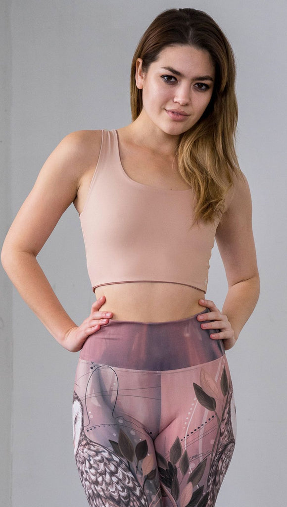  Three quarter length front view of model wearing a reversible beige/light skin tone crop top with a light brown/medium skin on the inside