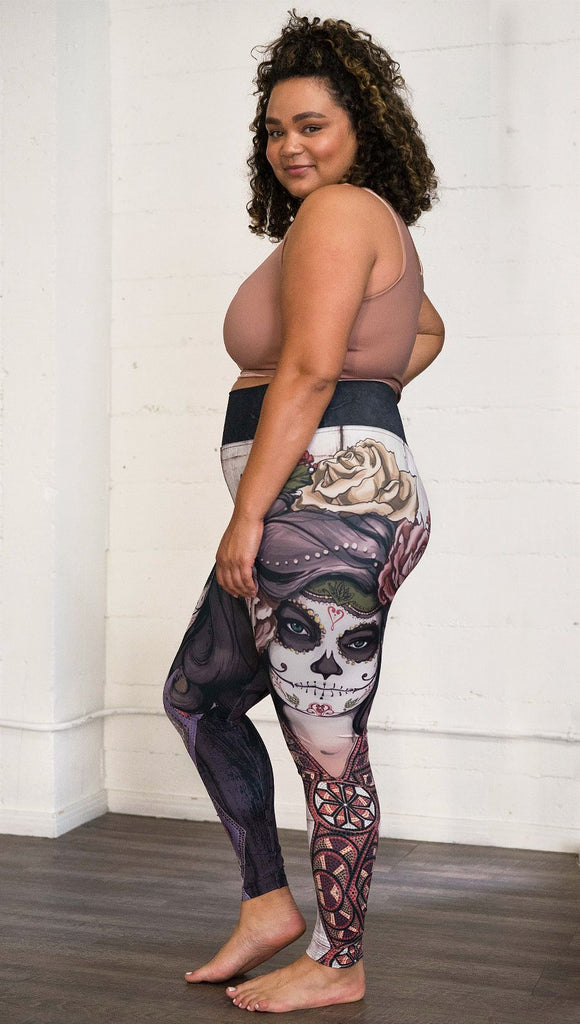 Right side view of model wearing mashup Sugar Skull and Dia De Los Muertos themed printed full length leggings
