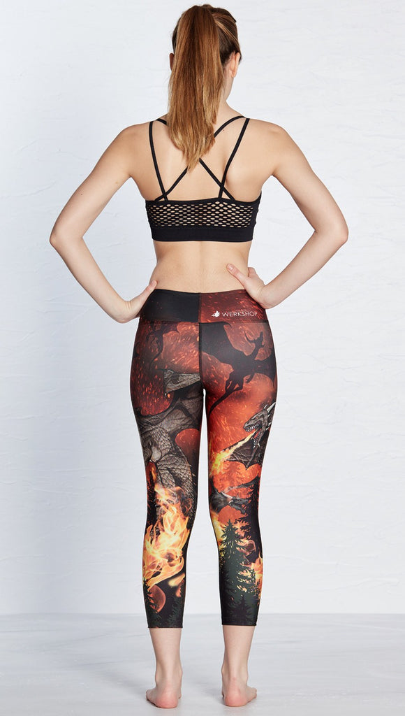 back view of model wearing fire breathing dragon themed printed capri leggings