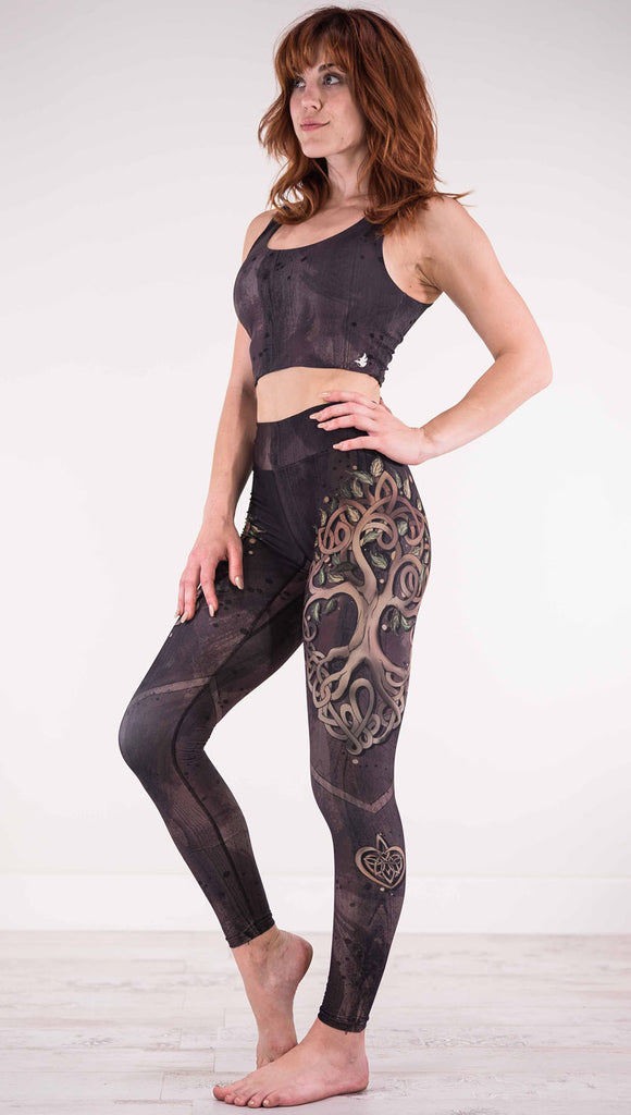 Left view of model wearing the Tree of Life triathlon leggings in a brown wood grain print with a tree on the side