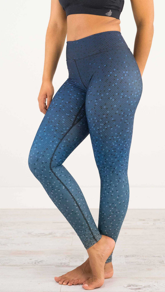 Waist down, side view of model wearing WERKSHOP Black Ombre Full Length Triathlon Leggings. The artwork is dark indigo blue on top and fades to a lighter blue on the bottom - with a lot of texture from bead-like artwork.
