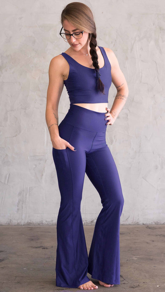Model wearing WERKSHOP Royal Blue Featherlight Bells. They are a bright blue color with a flared leg opening, pockets on the hip, have a high waistband and a flattering long panel gusset.