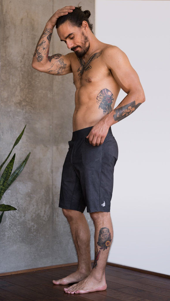 left side view of model wearing charcoal black printed mens performance shorts
