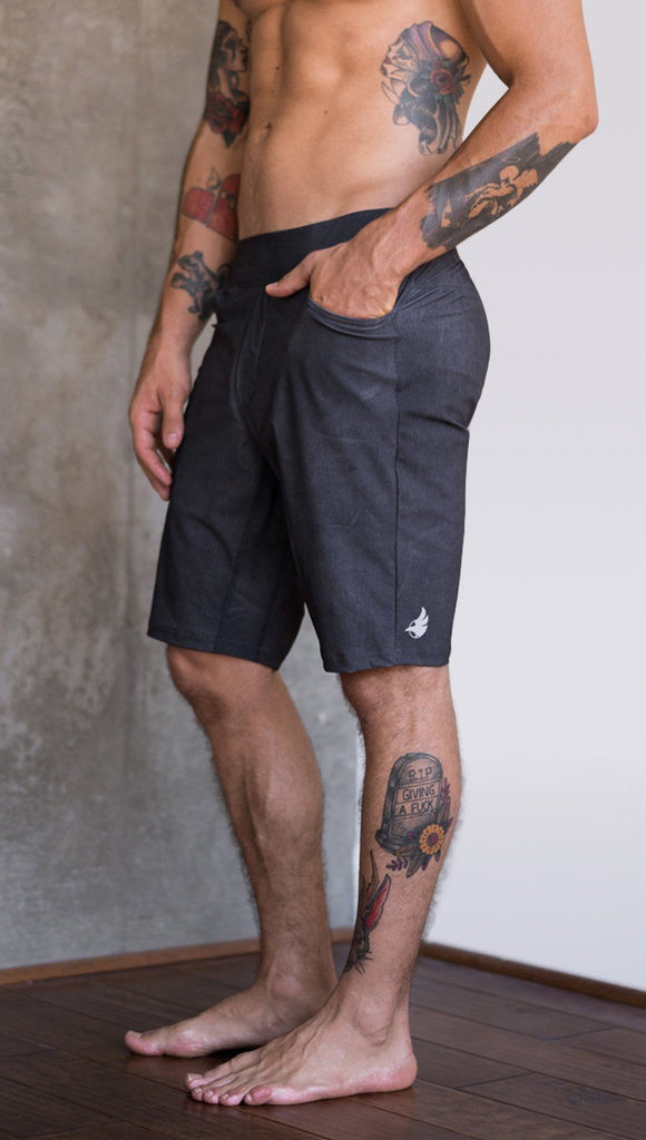 closeup left side view of model wearing charcoal black printed mens performance shorts