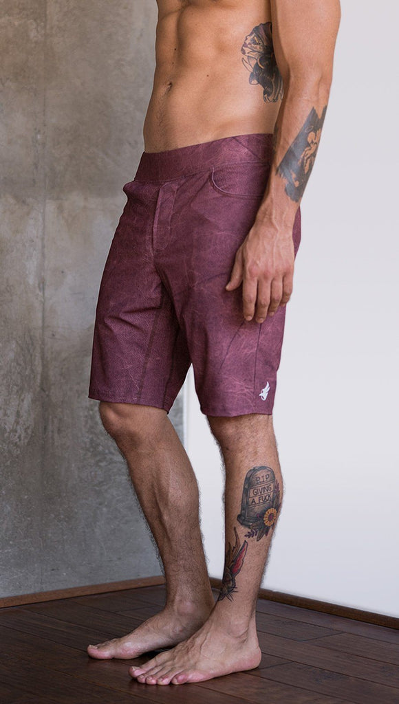 closeup left side view of model wearing brick red printed mens performance shorts