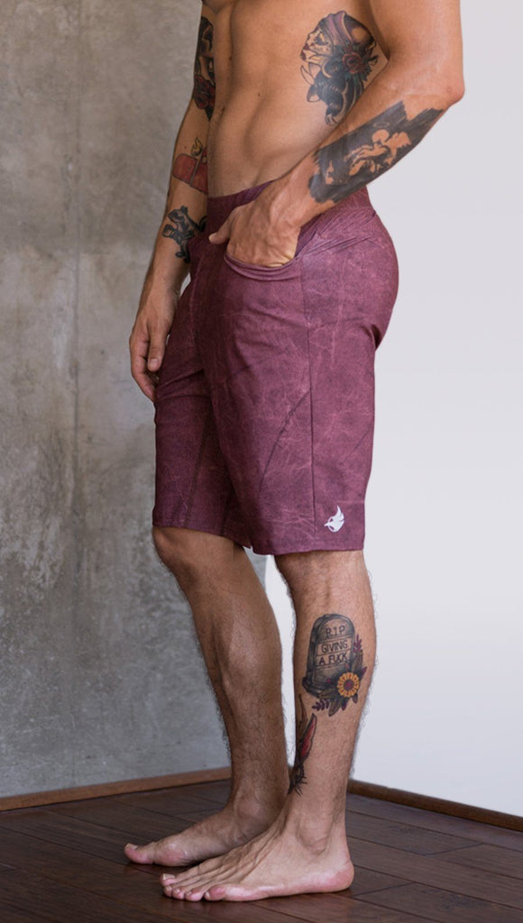 closeup left side view of model wearing brick red printed mens performance shorts