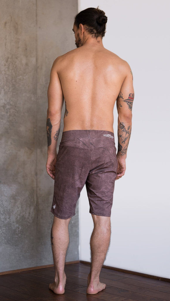 back view of model wearing cannabis inspired printed mens performance shorts