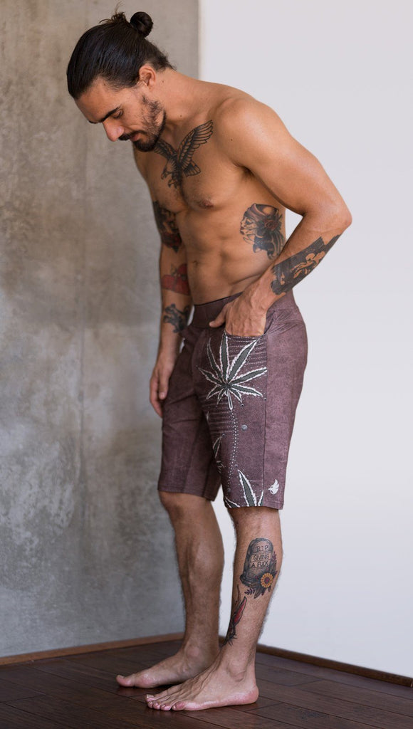 left side view of model wearing cannabis inspired printed mens performance shorts