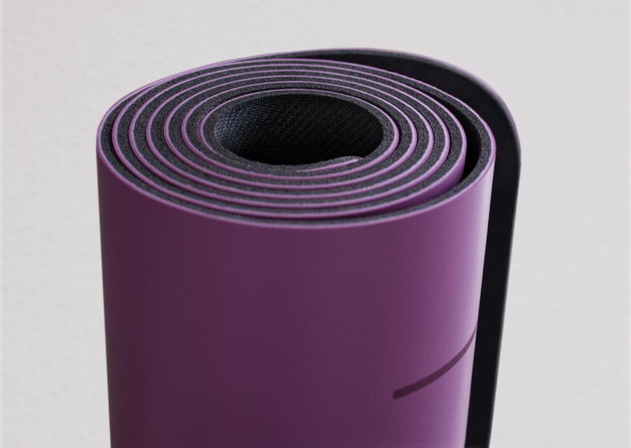 Closeup view of edge of rolled purple yoga mat