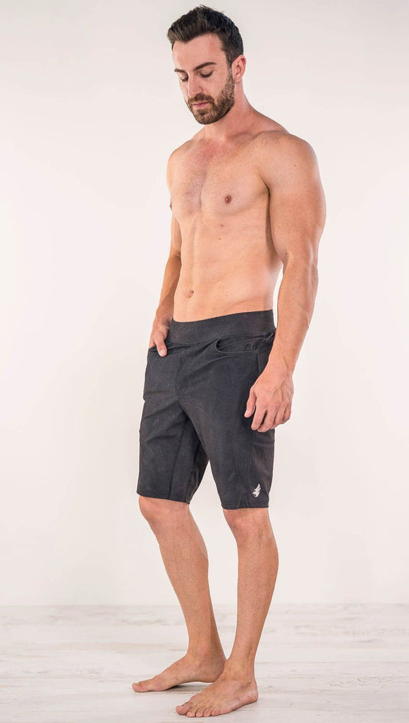 Diagonally left side view of model wearing charcoal black printed men's performance shorts