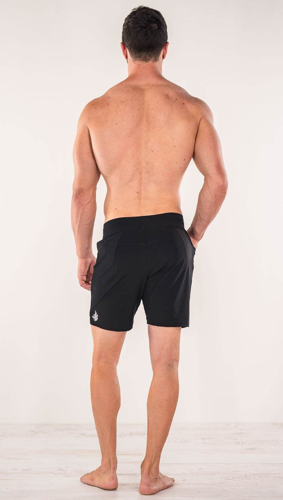 Back side view of model wearing black men's performance shorts