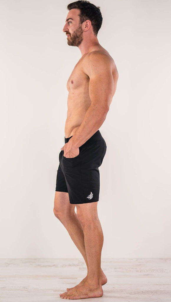 Right side view of model wearing black men's performance shorts