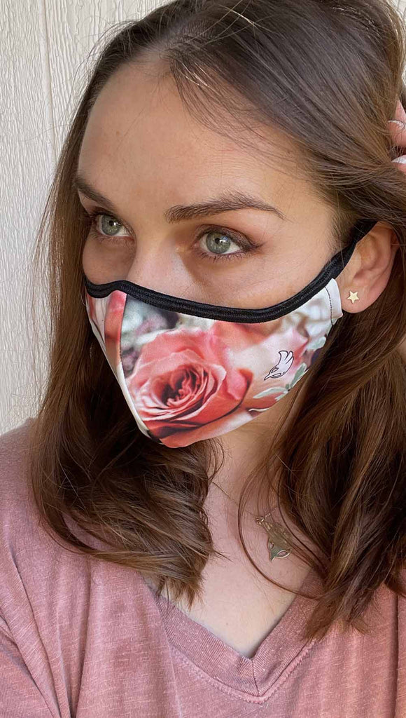 Girl wearing bodacious bouquet adjustable face mask - with soft cream, peach and warm pink roses