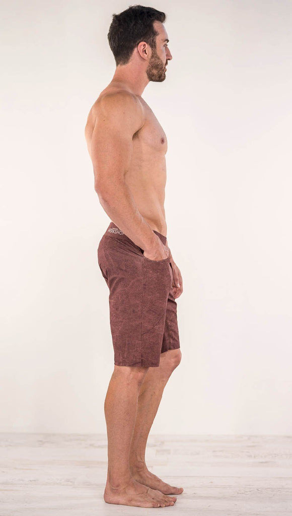 Right side view of model wearing brick red printed men's performance shorts