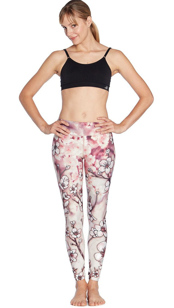 front view of model wearing cherry blossom themed printed full length leggings and sports top