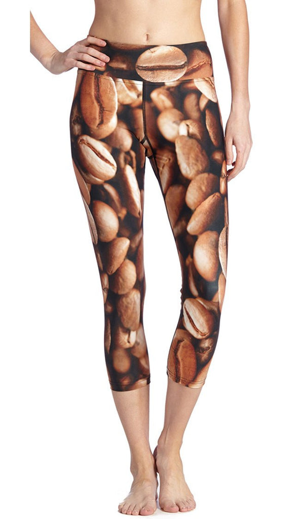 closeup front view of model wearing coffee bean themed printed capri leggings