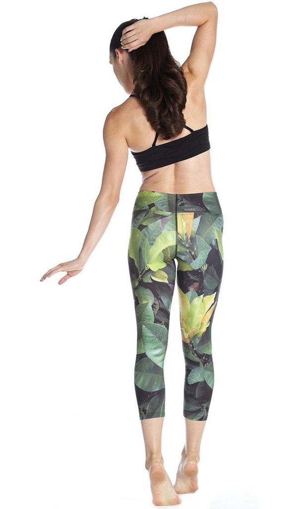 back view of model wearing tropical foliage themed printed capri leggings