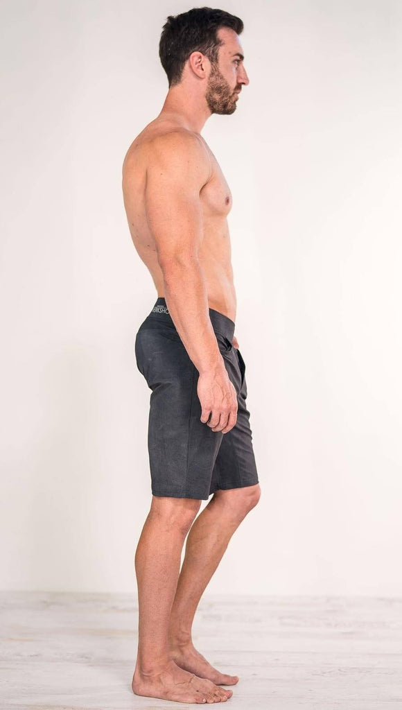Right side view of model wearing gray men's performance shorts