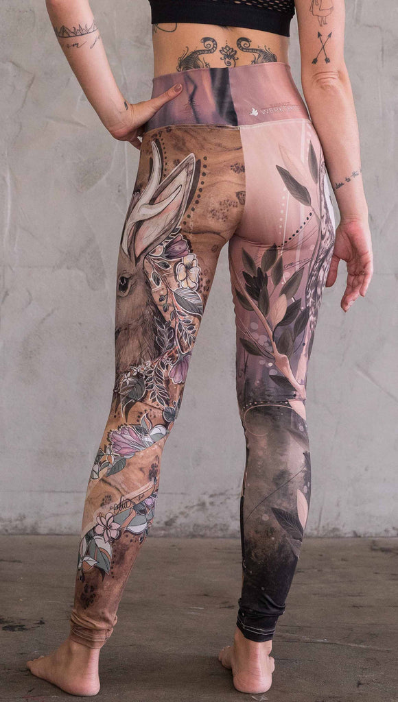 Back view of model wearing the jackalope/ owl mashup leggings in a light mauve and brown color. One leg has an owl and the other leg has a jackalope
