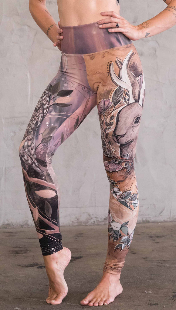 Left view of model wearing the jackalope mashup leggings in a light mauve and brown color. This leg has a large jackalope