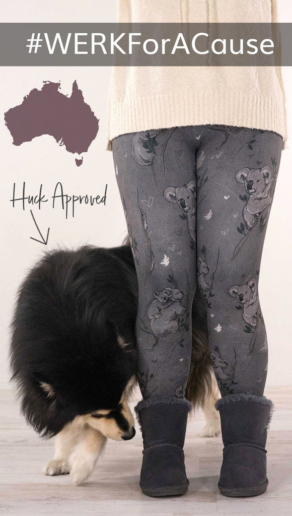Lower view of model wearing koala printed leggings with tree branches and leaves next to Finnish Lapphund dog