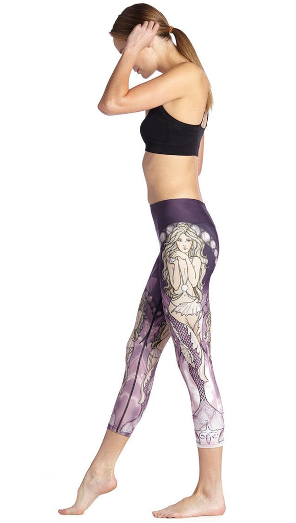 left side view of model wearing mermaid themed printed capri leggings