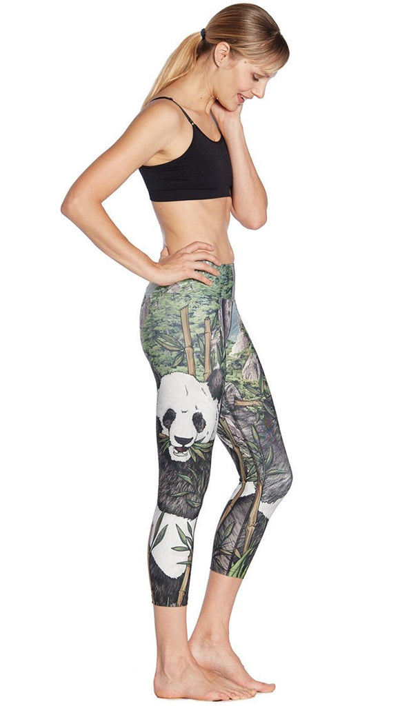 right side view of model wearing panda themed printed capri leggings