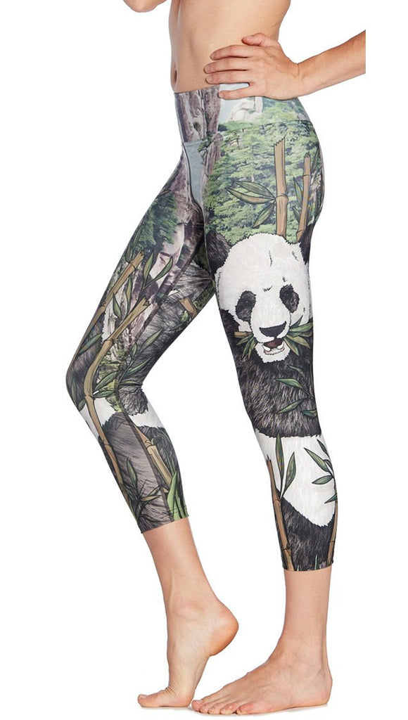 close up left side view of model wearing panda themed printed capri leggings