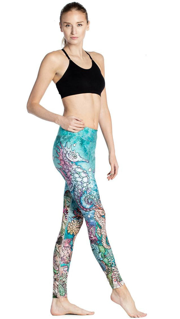 right side view of model wearing colorful seahorse themed printed full length leggings