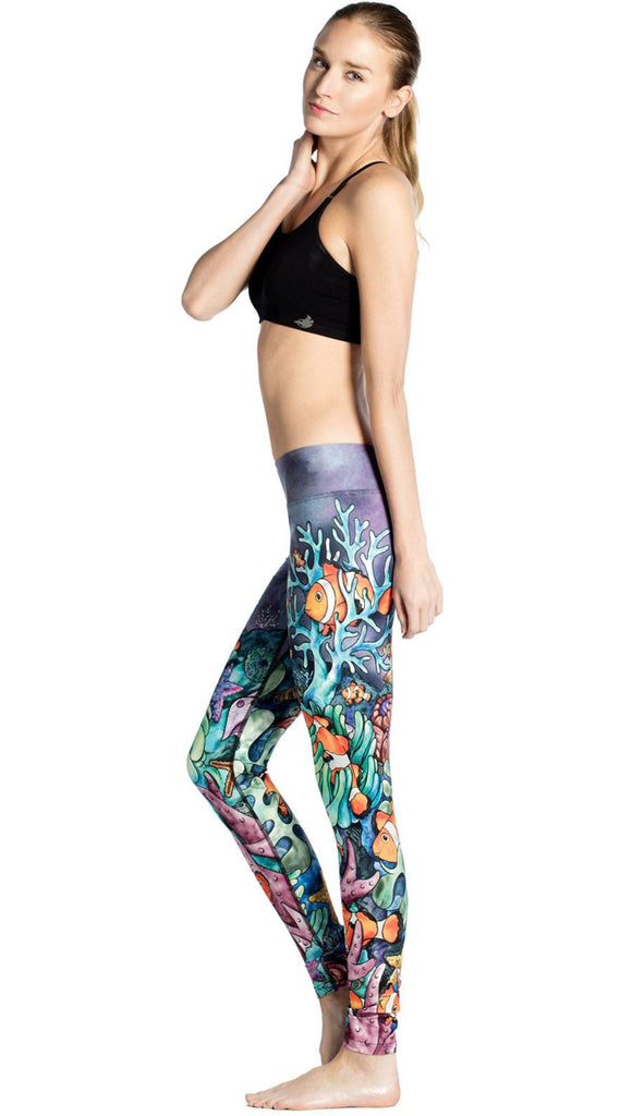 right side view of model wearing coral reef themed printed full length leggings