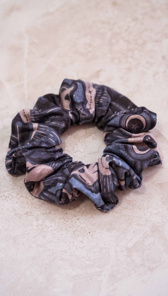 Tarot card themed printed hair scrunchie. The blue/tarot artwork has skulls, snakes, moons and the names of multiple popular tarot cards like "Strength, Lovers, Death and The Hanged Man" 